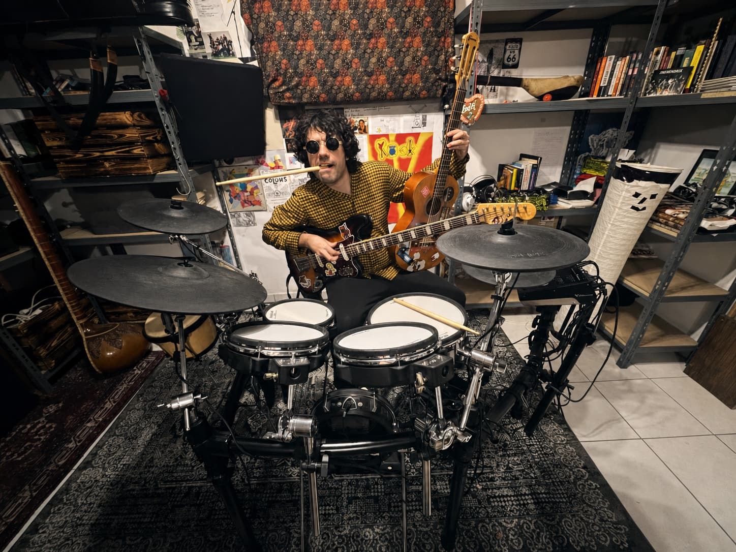 Rafael Belor spielt umgeben von Gitarren und Schlagzeug im Tonstudio